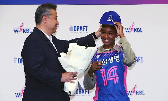 16일 인천 도원체육관에서 열린 '2022-2023 WKBL 신입선수 선발회'에서 1라운드 1순위로 삼성생명에 지명을 받은 키아나 스미스 선수가 임근배 감독에게 모자를 건네 받고 있다. 뉴스1