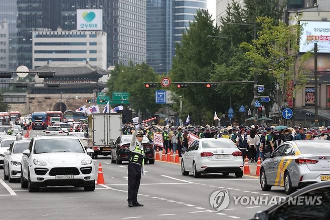 금융노조 가두행진에 통제되는 도로 (서울=연합뉴스) 신현우 기자 = 전국금융산업노동조합 조합원들이 16일 서울 중구 코리아나호텔 앞에서 총파업 대회를 마친 뒤 세종대로를 따라 용산 대통령실 방향으로 행진하고 있다. 2022.9.16 nowwego@yna.co.kr