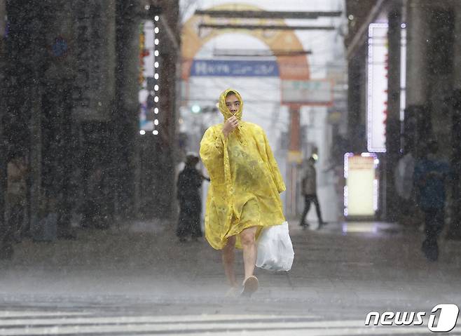 18일(현지시간) 일본 가고시마에서 제14호 태풍 난마돌의 영향으로 폭우와 비바람이 몰아치고 있는 가운데, 한 시민이 급히 길을 나서고 있다. ⓒ 로이터=뉴스1 ⓒ News1 김민수 기자