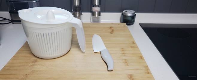 1~2만원대 주방용품들. 야채를 수월하게 씻는 야채탈수기(왼쪽), 무른 토마토와 칼에 달라붙는 오이 썰기에 적합한 세라믹 칼, 붙박이 장처럼 고정돼 사용하는 넓은 도마가 재료 손질에 도움을 준다. /사진=김고금평 기자