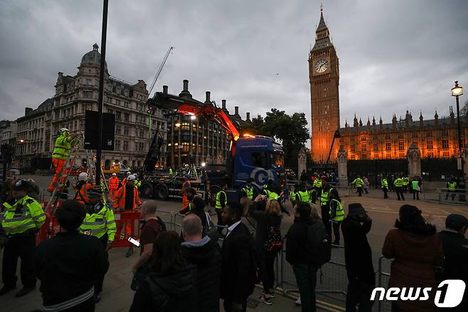 18일 오후(현지시간) 엘리자베스 2세 여왕의 관이 안치된 영국 런던 웨스트민스터 홀 앞에서 킴(34)씨가 '군주제를 폐지하라(Abolish the monarchy), 나의 왕(왕자)이 아니다(Not my king, not my prince)'라는 내용의 피켓을 들고 있다. 2022.9.19/뉴스1 ⓒ News1 안은나 기자