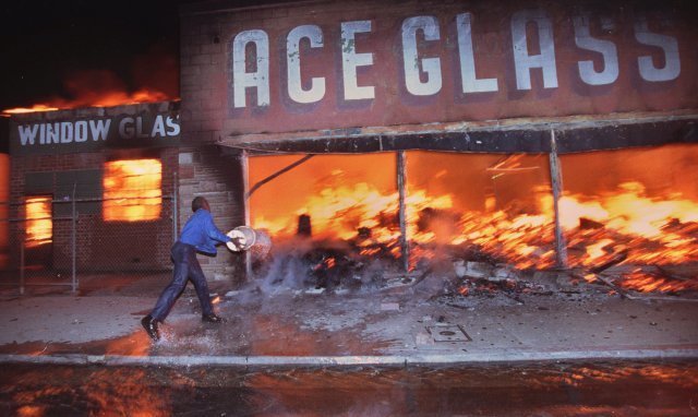 LA폭동. 강 기자가 퓰리처상을 받게 된 사건이다. Cornelius Pettus, owner of Payless market, throws a bucket of water on the flames at neighboring business Ace Glass in Los Angeles, California on April 29, 1992 during the first night of the 1992 Los Angeles Riots. 
Photo ⓒ  Hyungwon Kang/Los Angeles Times