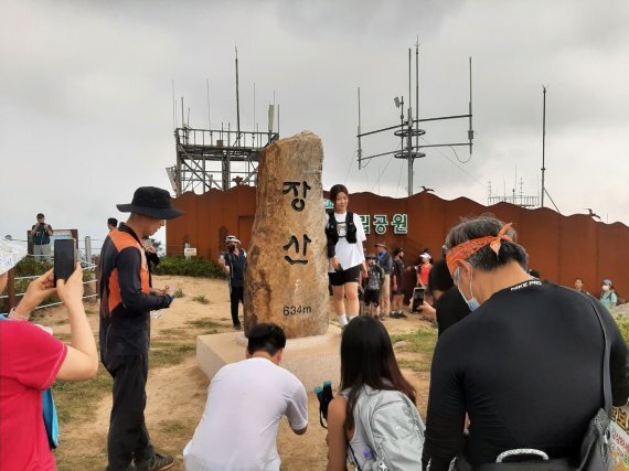 장산 정상에 세워진 표지석에서 시민들이 기념사진을 찍고 있다 해운대구 제공