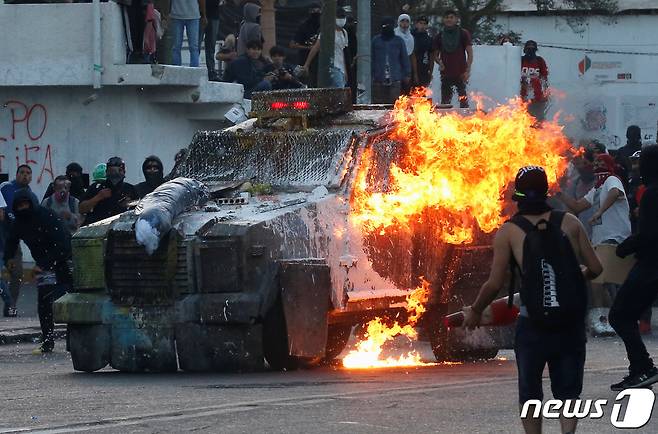 2019년 12월 칠레 발파라이소에서 반정부 시위대와 충돌로 경찰 장갑차가 불에 타고 있다. ⓒ 로이터=뉴스1 ⓒ News1 우동명 기자