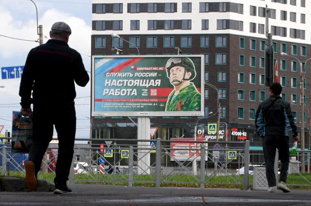 20일 러시아 상트페테르부르크 시내에 "러시아를 섬기는 것이 진짜 직업"이라고 적힌 모병 광고판이 걸려있다. 상트페테르부르크=AFP 연합뉴스