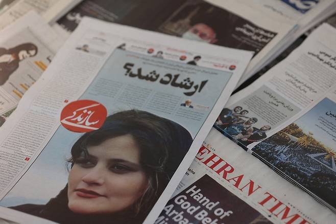 이란 테헤란에 지난 18일(현지시간) 구금 중 사망한 마흐사 아미니를 1면에 다룬 신문이 놓여 있다. 로이터연합뉴스