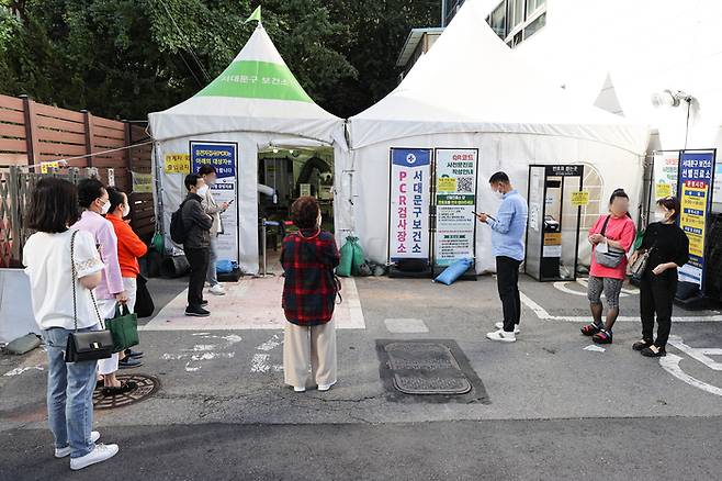 코로나19 재유행이 감소세를 보이는 가운데 21일 오전 시민들이 서울 서대문구 보건소에 마련된 선별진료소에서 검사 차례를 기다리고 있다. 연합뉴스