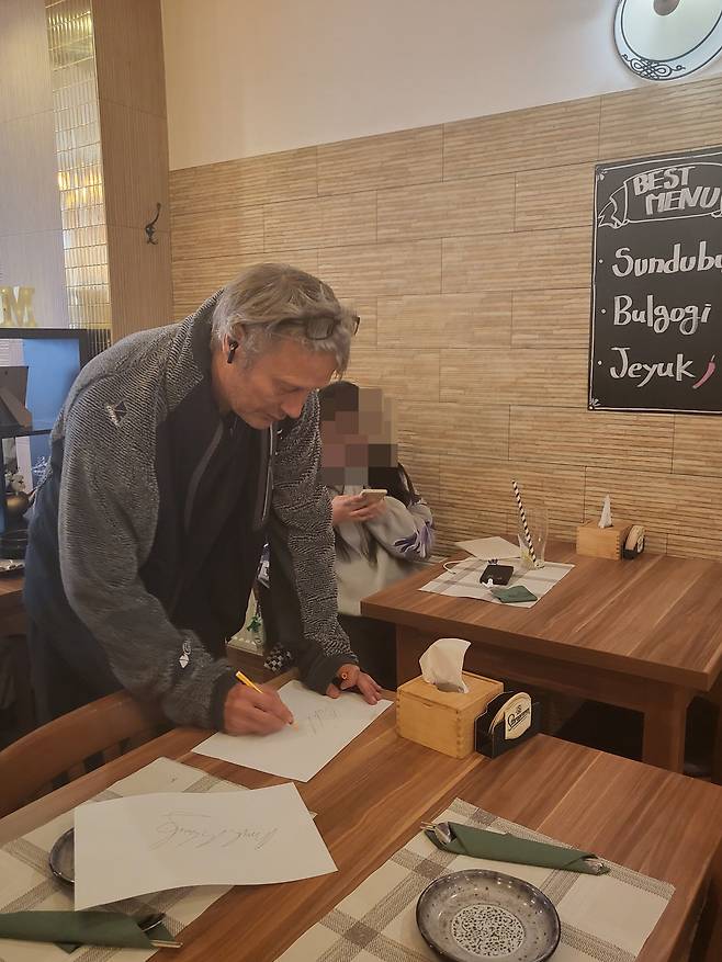 20일(현지시각) 프라하 한식당 '맛집'에서 식사 후 사인하는 매즈 미켈슨/'맛집' 탁경아 사장 제공