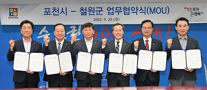 백영현 포천시장과 최춘식 국회의원, 서과석 포천시의회의장, 박기준 철원군의회의장, 한기호 국회의원, 이현종 철원군수(오른쪽부터)가 협약서를 들고 파이팅을 외치고 있다.(사진=포천시 제공)