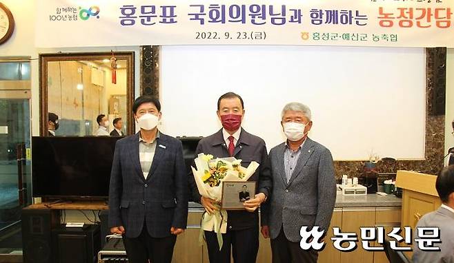 23일 열린 농정간담회에서 홍문표 의원이 조합장들로부터 감사패와 꽃다발을 받고 있다. 조합장들은 홍 의원이 평소 농업·농촌 발전을 위해 많은 노력을 기울였다며 감사패를 준비했다.