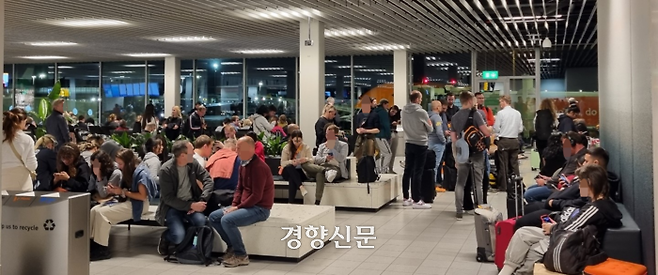 지난 19일 네덜란드 스키폴공항에서 이용객들이 항공기 탑승을 위해 대기하고 있다. 이용객들 대부분 마스크를 쓰지 않고 있다.