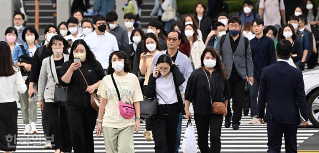 실외 마스크 착용 의무가 해제된 26일 오전 서울 영등포구 여의대로 횡단보도에서 마스크를 쓴 시민들이 출근을 서두르고 있다. 배우한 기자