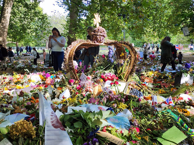 25일(현지시간) 영국 왕가가 있는 버킹엄궁 인근 공원에 시민들이 남긴 추모 메시지와 꽃들. 김성우 기자