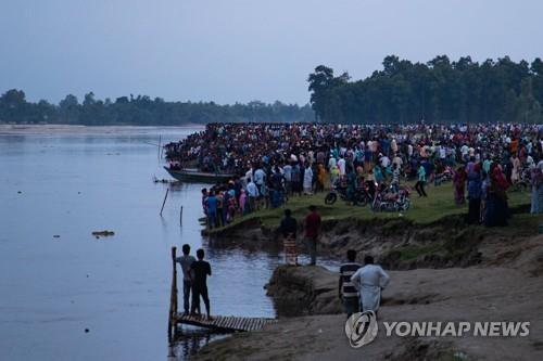 선박 전복 사고가 발생한 방글라데시 카라토아강 인근에 사람들이 모인 모습. [AFP 연합뉴스 자료사진. 재판매 및 DB 금지]