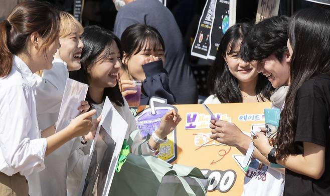 실외 마스크 착용 의무가 해제된 26일 서울 동작구 흑석동 중앙대학교에서 열린 가을축제에서 연극동아리 타박네와 광고홍보전람회 학생들이 운세뽑기 이벤트를 하며 활짝 웃고 있다. /박상훈 기자