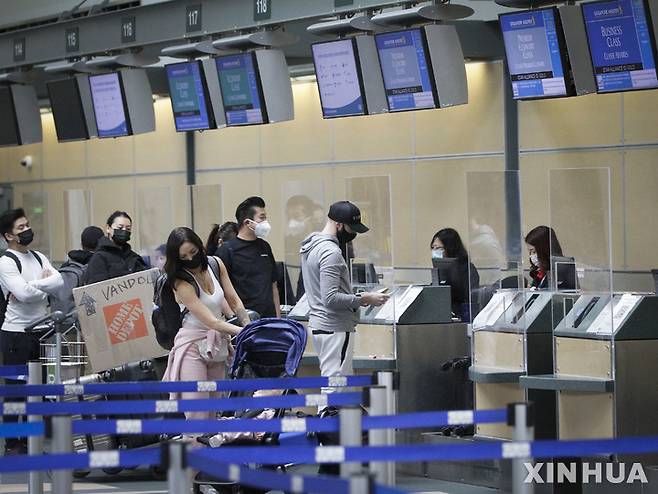 [ 리치먼드 ( 캐나다 브리티시 콜럼비아주)= 신화/뉴시스]캐나다 리치먼드 국제공항에서 지난 달 15일 마스크를 착용한 여행객들이 항공사카운터 앞에서 수속을 기다리고 있다.  캐나다는 오미크론 감염이 정점을 지난 2월 28일부터 입국자에 대한 즉석 진단검사를 면제하기 시작했다.