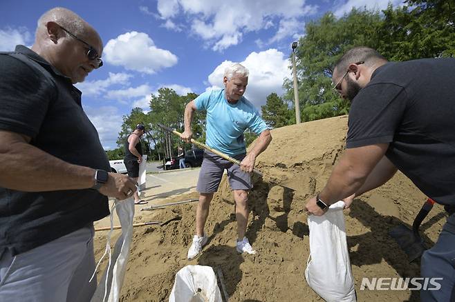 [올랜도=AP/뉴시스] 26일(현지시간) 미 플로리다주 올랜도의 오렌지카운티 공원에서 주민들이 허리케인 이언의 상륙에 대비해 모래주머니를 만들고 있다. 2022.09.27.