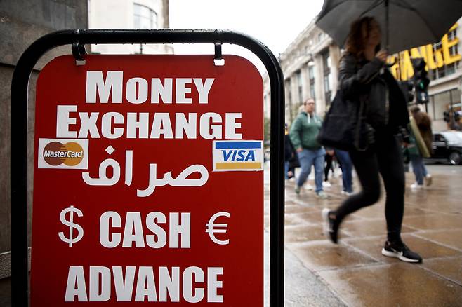 26일(현지시각) 시민들이 영국 런던의 한 환전소 앞을 지나가고 있다. 런던/AP 연합뉴스