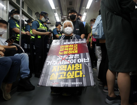 전국장애인차별철폐연대(전장연) 회원들이 13일 오전 서울 5호선 동대문역사공원역 지하철에서 장애인권리예산 삭감을 규탄하며 제36차 출근길 지하철 탑승 시위를 벌이고 있다.전장연은 이날 오전 4호선 삼각지역에서 2개 조로 나눠 2, 4, 5, 9호선 등 지하철을 타고 국회의사당역으로 향했다. 2022.9.13 연합뉴스