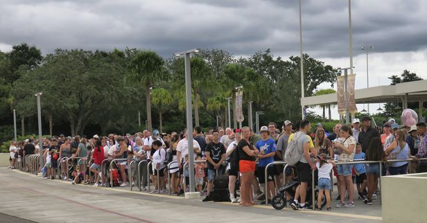 2022년 9월 27일(현지 시간) 미국 플로리다 레이크부에나비스타에서 허리케인 '이언'으로 월트디즈니월드 공원이 문을 닫자 관람객들이 돌아가는 교통편을 타기위해 줄을 서 있다./AP 연합뉴스