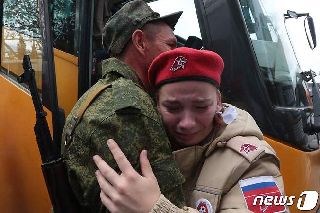 27일(현지시간) 크름반도 세바스토폴에서 블라디미르 푸틴 러시아 대통령의 부분 동원령에 따라 징집된 예비군들이 작별식에서 가족과 포옹하며 울먹이고 있다. ⓒ AFP=뉴스1 ⓒ News1 우동명 기자