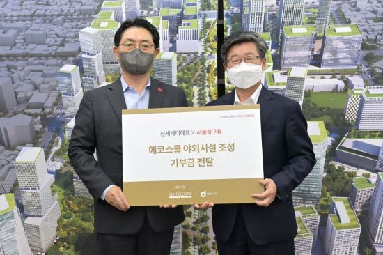 문현규 신세계면세점 본점장(왼쪽)과 김길성 서울 중구청장이 에코스쿨 조성 기금 전달식 후 기념사진을 찍고 있다.