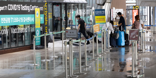 지난달 4일 오후 인천공항을 통해 입국한 외국인 여행객들이 코로나19 검사를 받기 위해 공항 내 검사소에 대기하고 있다. <연합뉴스>