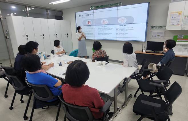 서울 성수동 행복커넥트 ICT 관리센터에서 진영하 심리상담사와 현장 케어 매니저들이 회의를 하고 있다.