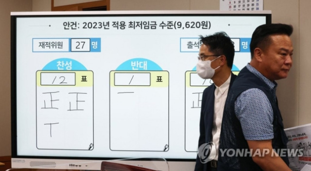 올해 6월 30일 오전 세종시 정부세종청사 최저임금위원회 회의실에서 열린 제8차 전원회의에서 내년도 최저임금이 결정됐다. 박준식 위원장(왼쪽)과 근로자 위원인 이동호 한국노총 사무총장이 인사한 뒤 돌아서고 있다.연합뉴스