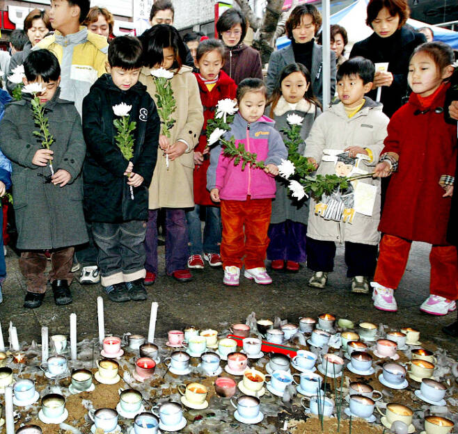 대구지하철화재참사 추모의날에 중앙로역 사고현장 앞에서 아이들이 애도의 묵념을 하고 있다.[사진 = 매경 DB]