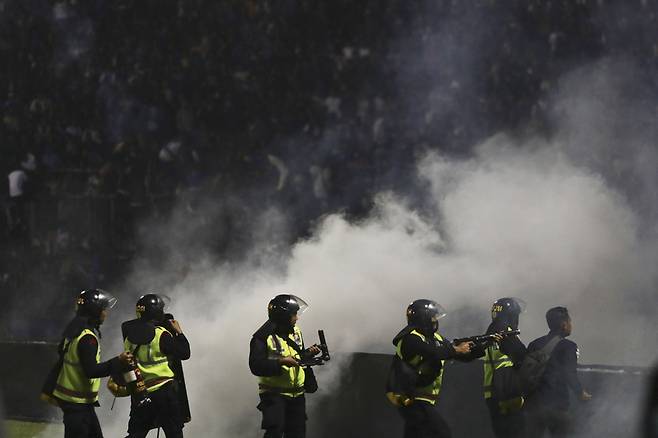 1일(현지시각) 인도네시아 자바 축구경기장에서 발생한 폭동으로 최소 127명이 사망했다. 경찰들이 폭동이 발생한 칸주루한 경기장에서 최루탄을 쏘고 있다.  / AP=연합뉴스