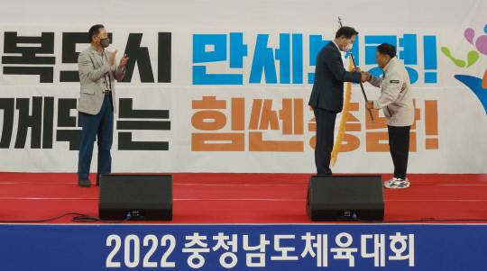 김덕호 충청남도체육회장이 차기 개최지인 금산군 정해천 체육회장에게 대회기를 전달하고 있다. 사진=충남체육회 제공