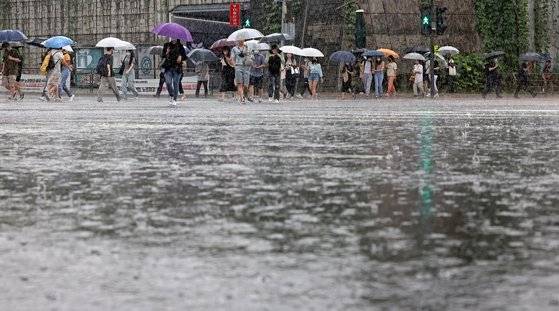 서울에 호우주의보가 발효 중인 지난 7월 13일 서울 서대문구 연세대학교 앞 횡단보도에서 학생 등 시민들이 우산을 쓴 채 걸어가고 있다. 연합뉴스