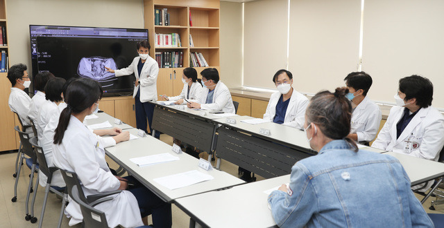 고려대구로병원 대장암 다학제팀 의료진이 50대 대장암 환자(청재킷 입은 이)의 수술 및 항암치료 계획에 대해 논의하고 있다. 대장항문외과, 종양내과, 간담췌외과, 이식혈관외과, 정형외과, 영상의학과, 핵의학과, 방사선종양학과 8개 진료과 교수들이 다학제팀에 참여한다. 고려대의료원 제공