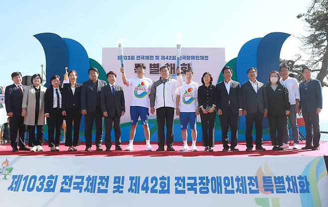 [울산=뉴시스] 박수지 기자 =울산시 동구가 30일 대왕암공원 해맞이 광장에서 제103회 전국체전 및 제42회 전국장애인체육대회 특별채화식을 가진 가운데 김종훈 동구청장이 성화 불꽃을 점화해 첫 번째 주자에게 전달하고 기념촬영을 하고 있다. 2022.09.30. (사진=동구 제공) photo@newsis.com *재판매 및 DB 금지