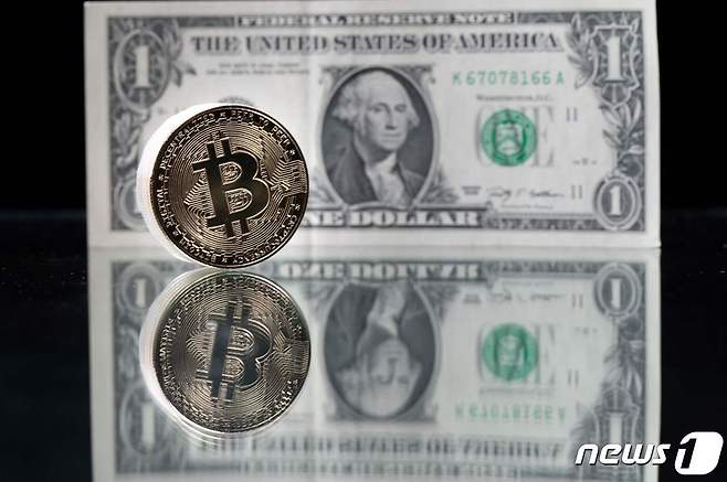 미국 1달러 지폐와 비트코인의 이미지를 담은 동전. ⓒ AFP=뉴스1
