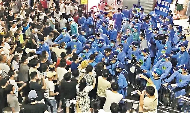 중국 광둥성 선전시의 봉쇄 지역 주민들이 경찰과 대치하며 봉쇄 해제를 요구하고 있다. 홍콩 명보 캡처·연합뉴스