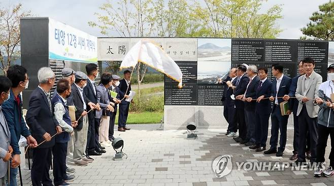 세종시 태양 12경 시비 제막식    (세종=연합뉴스) 이은파 기자 = 4일 세종시 반곡동 삼성천 옆에서 열린 '태양 12경 시비 제막식'에서 세종시 건설로 사라진 옛 충남 연기군 금남면 반곡리(현 세종시 반곡동) 주민들이 시비 명을 덮은 막을 걷어내고 있다. 2022.10.4 sw21@yna.co.kr