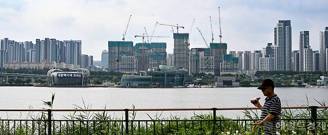 지난달 서울 내 부동산을 산 외국인의 수는 최근 9년 사이 최저인 것으로 나타났다. 달러 강세 속 환율의 이점을 극대화할 수 있는 상황에서도 외국인들의 국내 부동산 매수가 줄어든 데에는 경기침체를 우려하며 국내 부동산 가격의 하락을 예측하는 외국인들이 늘어나고 있기 때문이라는 분석이다. 사진은 서울 용산구 이촌동에서 산책 중인 시민 뒤로 반포 아파트 일대가 보인다. 임세준 기자