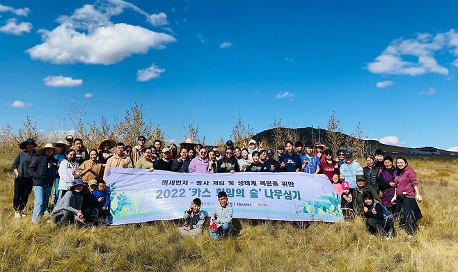 몽골 학생 봉사단이 몽골 북동부 에르덴솜 지역에서 나무심기 봉사활동 마치고 단체 사진을 찍고 있다.(오비맥주 제공)
