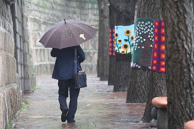 중부지방에 비가 예보된 지난 3일 오전 서울 중구 덕수궁 인근에서 한 시민이 우산을 쓴 채 이동하고 있다. 연합뉴스