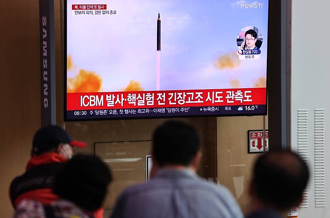 Passersby watch a TV report of North Korea`s missile launch at Seoul Station on Thursday. (Yonhap)