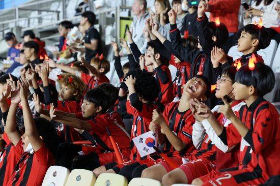 실외 마스크 착용 의무가 전면 해제된 지난달 26일 오후 올림픽 축구 대표팀 평가전 한국과 우즈베키스탄의 경기가 열리는 경기도 화성종합경기타운 주 경기장을 찾은 어린이들이 마스크를 벗고 열띤 응원을 하고 있다. [이미지출처=연합뉴스]