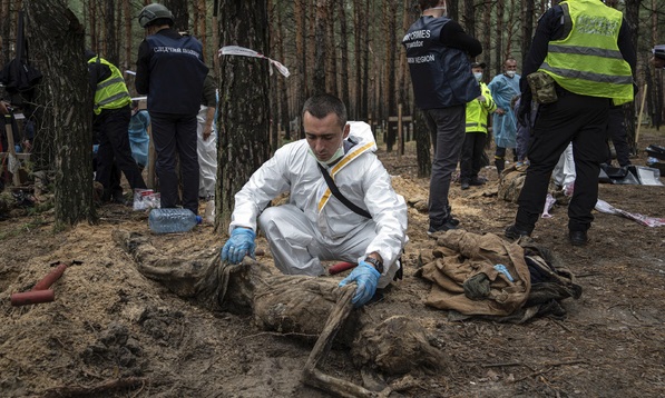 우크라이나 하르키우주 이지움의 시신 440구가 묻힌 집단 매장지에서 조사관들이 시신 발굴 및 조사 작업을 벌이고 있다. AP뉴시스
