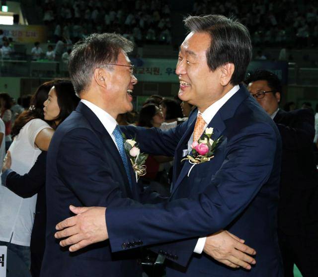 2015년 9월 2일 서울 장충체육관에서 열린 가정어린이집 보육인대회에서 문재인(왼쪽) 당시 새정치민주연합 대표, 김무성 새누리당 대표가 사회자의 안내에 따라 손을 맞잡은 후 포옹하고 있다. 한국일보 자료사진