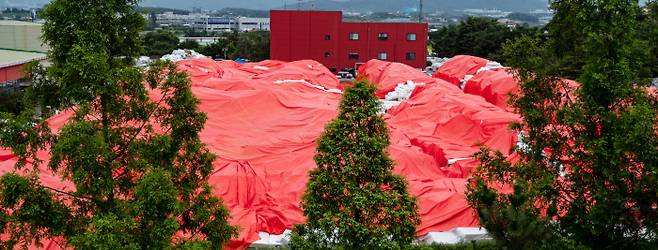 2018년 7월 충남 천안시 대진침대 본사에 수거한 매트리스 2만여개가 빨간 방수포에 싸인 채 놓여 있다. 경향신문 자료사진