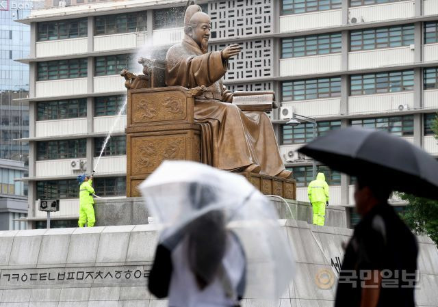 서울 시민들이 2018년 7월 9일 광화문광장 세종대왕동상 주변을 우산을 쓰고 지나가고 있다. 국민일보 DB