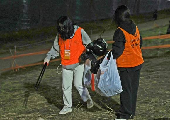 8일 오후 서울세계불꽃축제 불꽃쇼가 끝난 여의도 한강공원에서 봉사자들이 버려진 쓰레기를 정리하고 있다. 2022.10.8 서울 연합뉴스