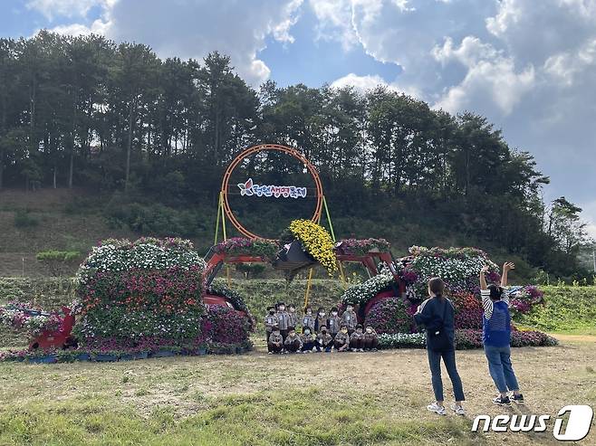 충북 청주시 청원구 오창읍 미래지테마공원에서 열린 '2022 청원생명축제'에 방문한 관람객들이 트랙터 꽃차 앞에서 기념촬영을 하고 있다.(청주시 제공).2022.10.10/뉴스1