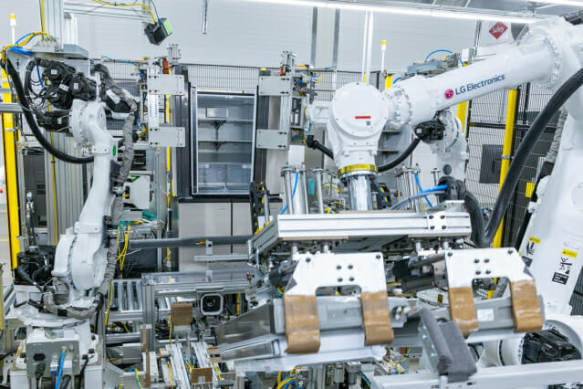 LG스마트파크 통합생산동 생산라인에 설치된 로봇팔이 20킬로그램(kg)이 넘는 커다란 냉장고 문을 가뿐히 들어 본체에 조립하는 모습(사진=LG전자)